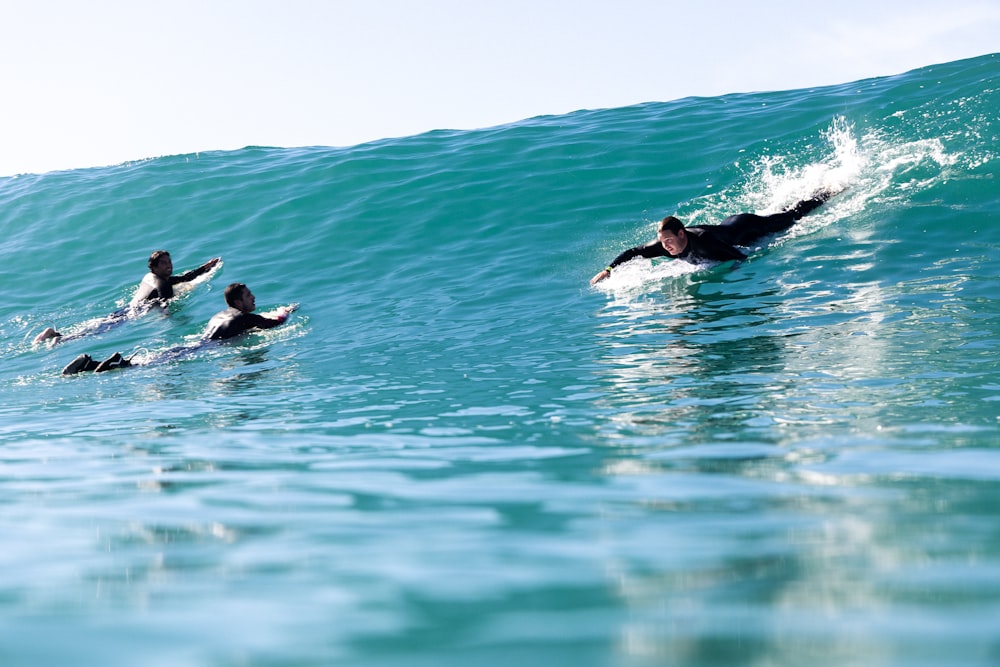 a group of people riding on top of a wave in the ocean