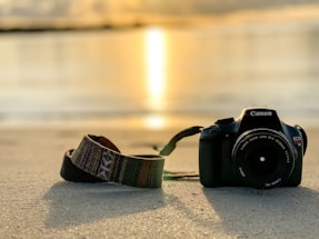 A warm, inviting photo of a camera resting on a sunlit beach in Tenerife.