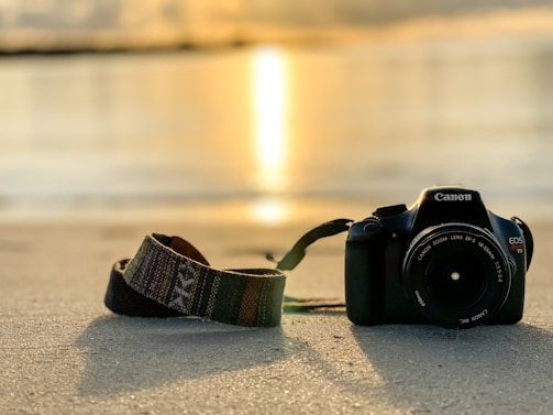 A warm, inviting photo of a camera resting on a sunlit beach in Tenerife.