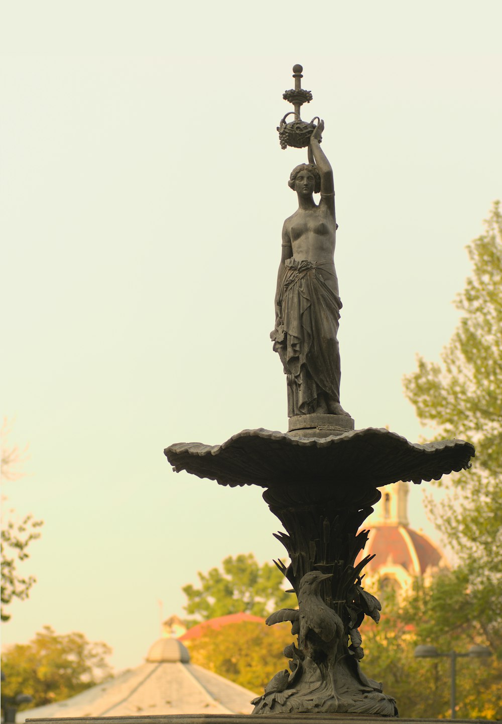 Eine Statue einer Frau, die eine Lampe auf einem Brunnen hält