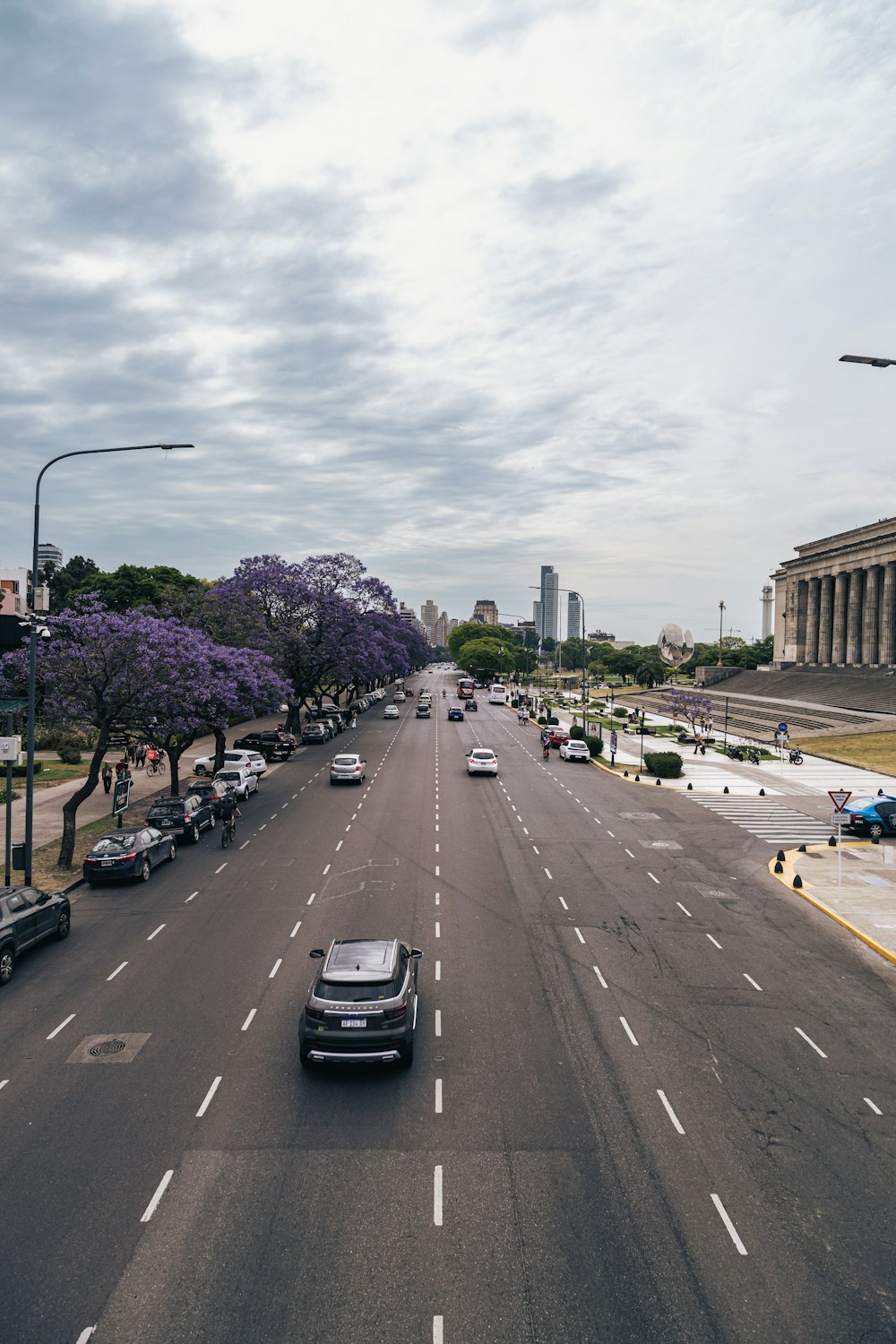 a car driving down a street next to tall buildings