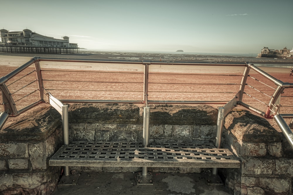 a bench sitting on top of a stone wall