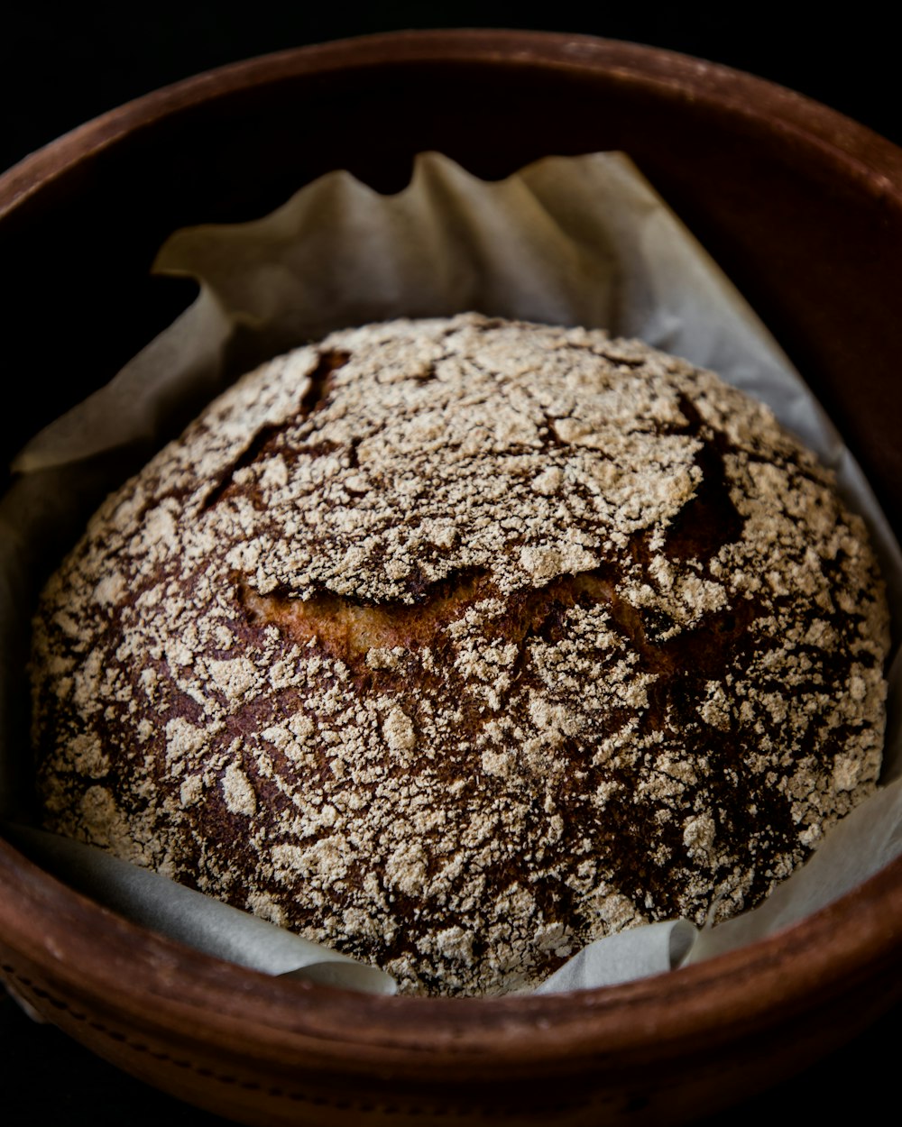 a loaf of bread in a wooden bowl