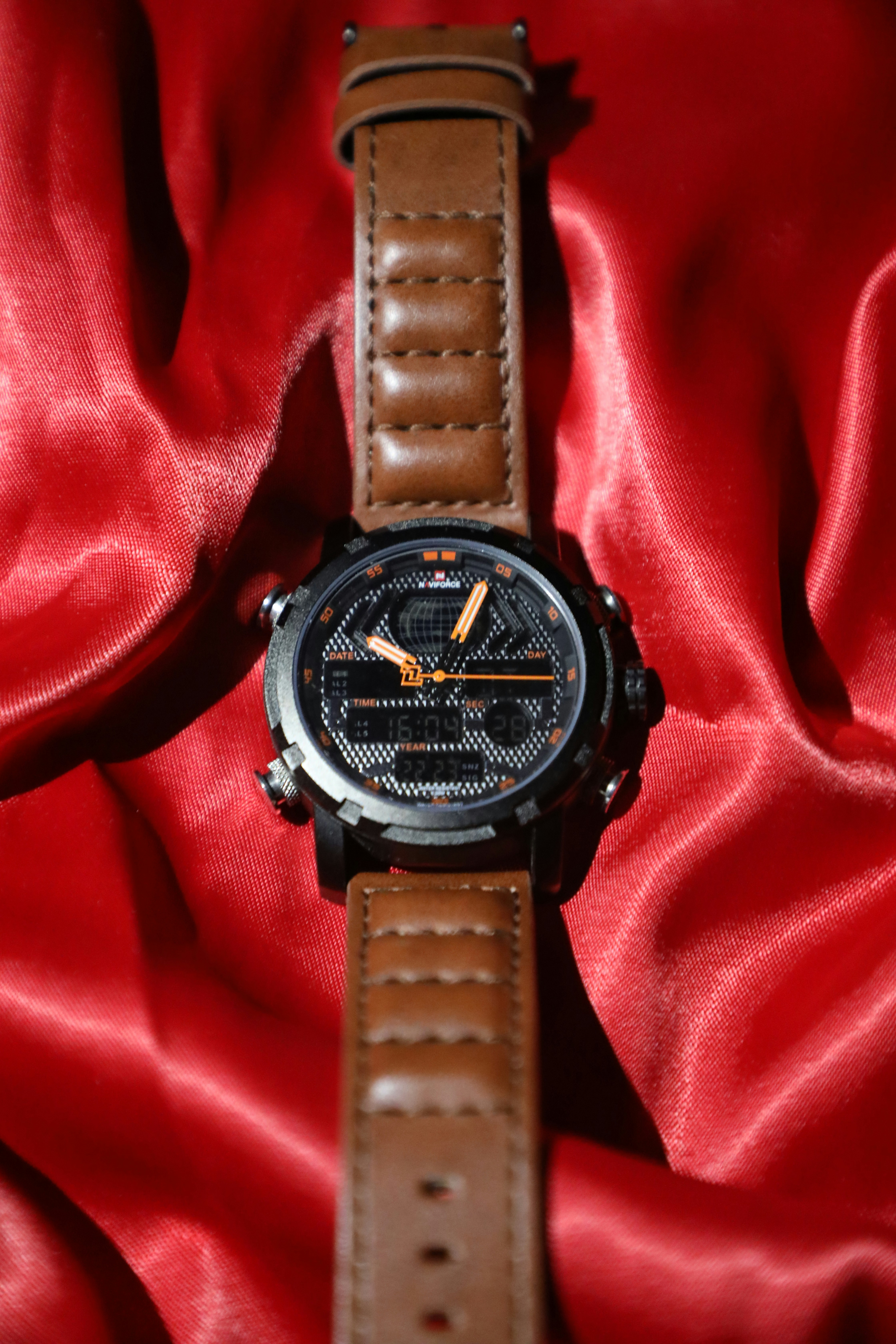 a watch sitting on top of a red cloth
