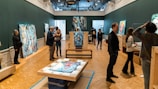 Visitors engaging with original artworks in a 3D space.