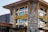 A rustic building features a prominent signage with the words 'Lazy Dog' in bright yellow letters. The structure is made of stone and wood, with large windows. The ambiance suggests a cozy eatery or bar.