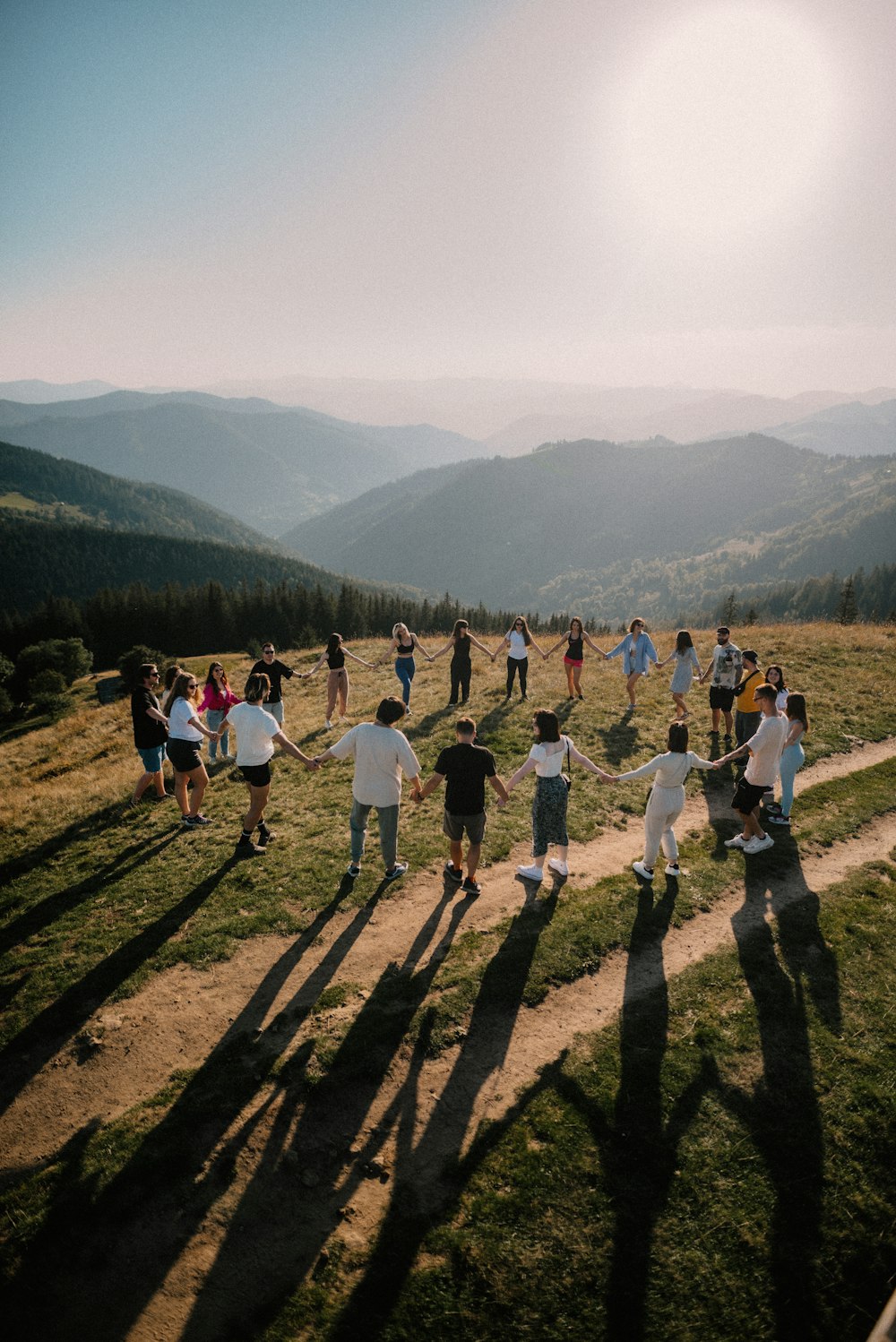 a group of people standing on top of a lush green hillside