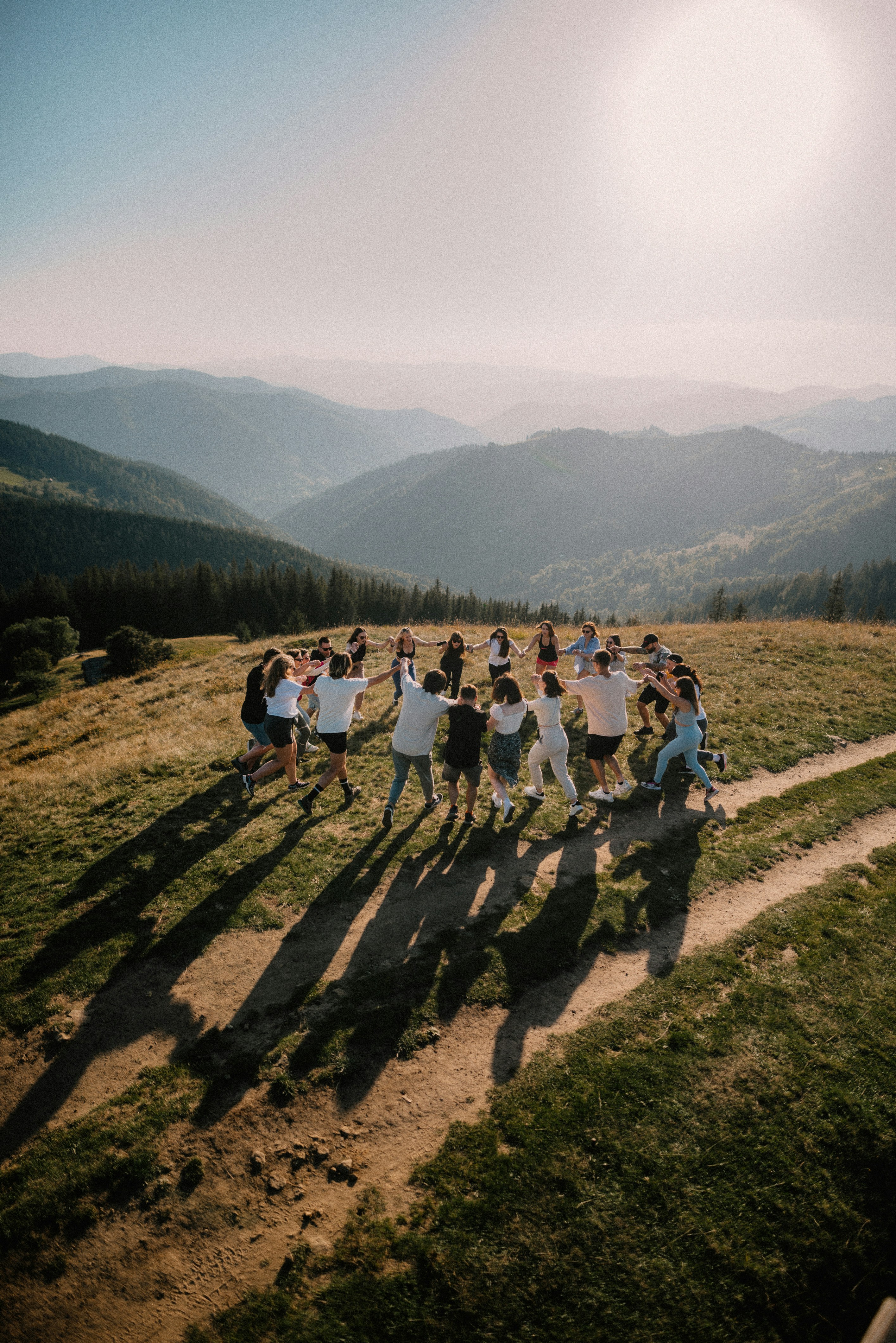 a group of people standing on top of a lush green hillside