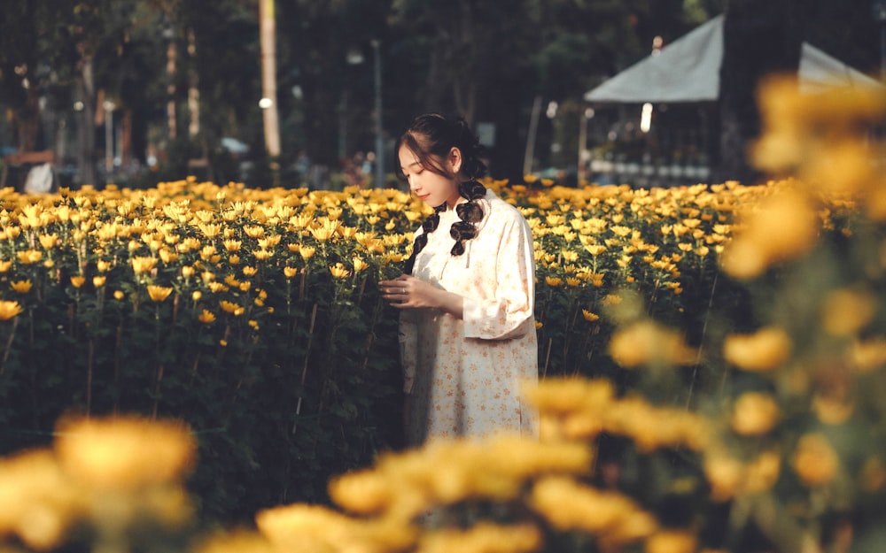 a woman standing in a field of yellow flowers