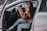 A person happily listening to a satellite radio in their car.