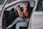A person happily listening to a satellite radio in their car.