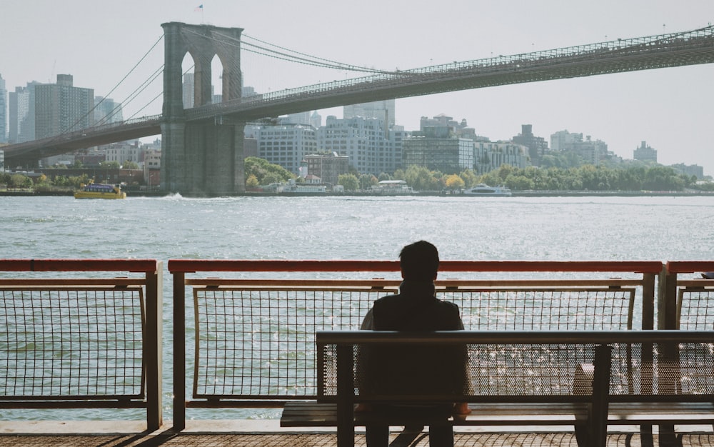 a person sitting on a bench near a body of water