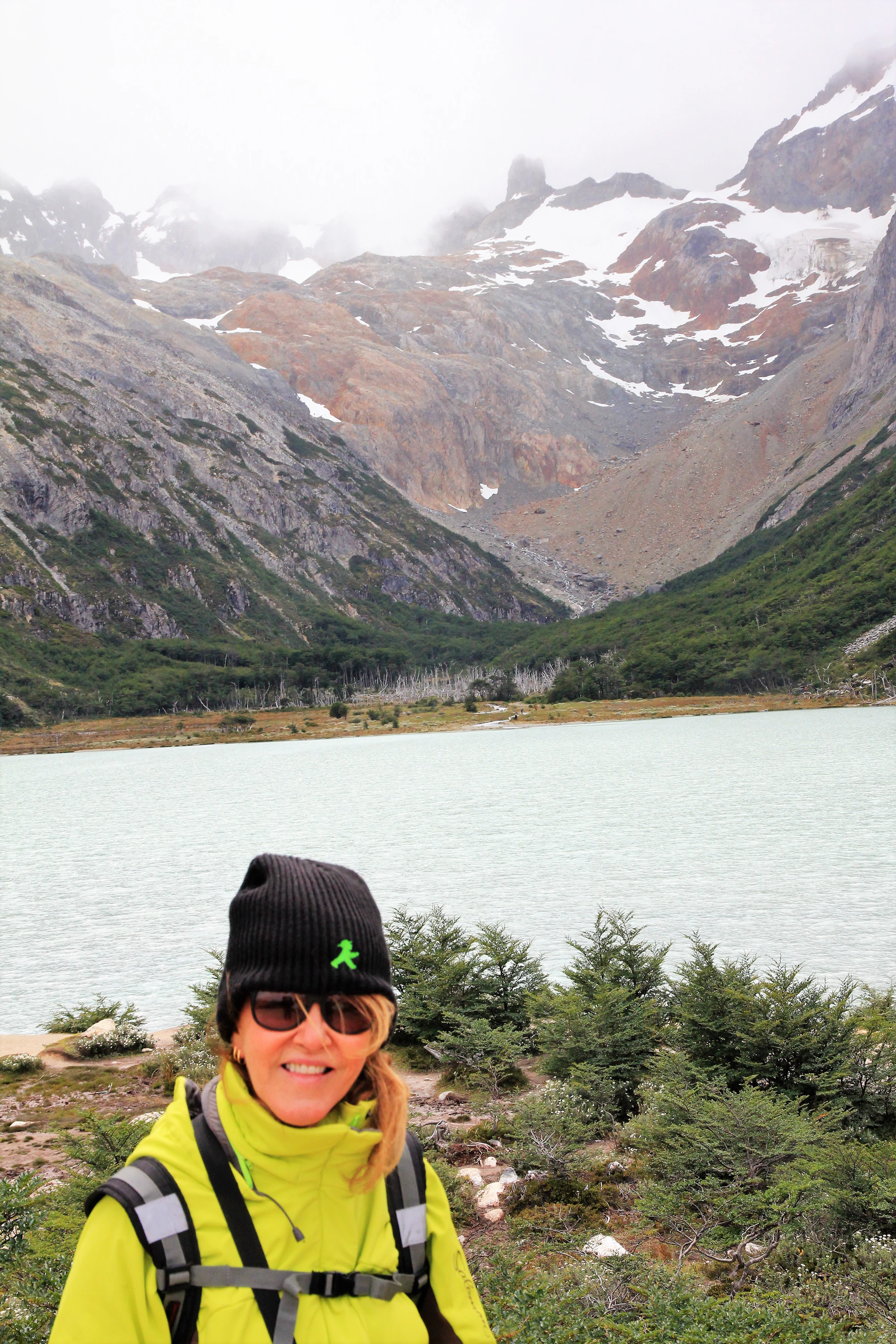 Black woman traveler overlooking a cool mountain lake while planning a summer coolcation