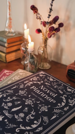 a table topped with books and a vase filled with flowers