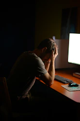 a man sitting at a desk in front of a computer