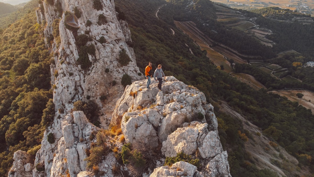 a couple of people standing on top of a mountain