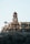 A large, luxurious villa with Mediterranean architectural style, featuring arched windows and balconies. The building has multiple levels and a central tower with a dome. Palm trees are situated around the structure, and it is located on a rocky cliff, suggesting a coastal setting.