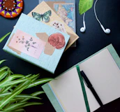 A calm morning scene with a journal, glasses, and a plant on a wooden desk.