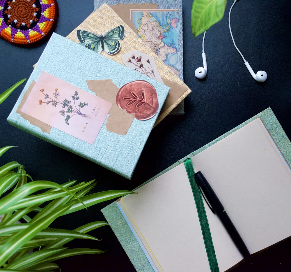 a table with a notebook, headphones, and a pen