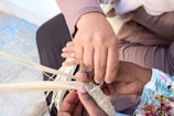 Close-up of hands weaving a vibrant tapestry in an arts and crafts session.