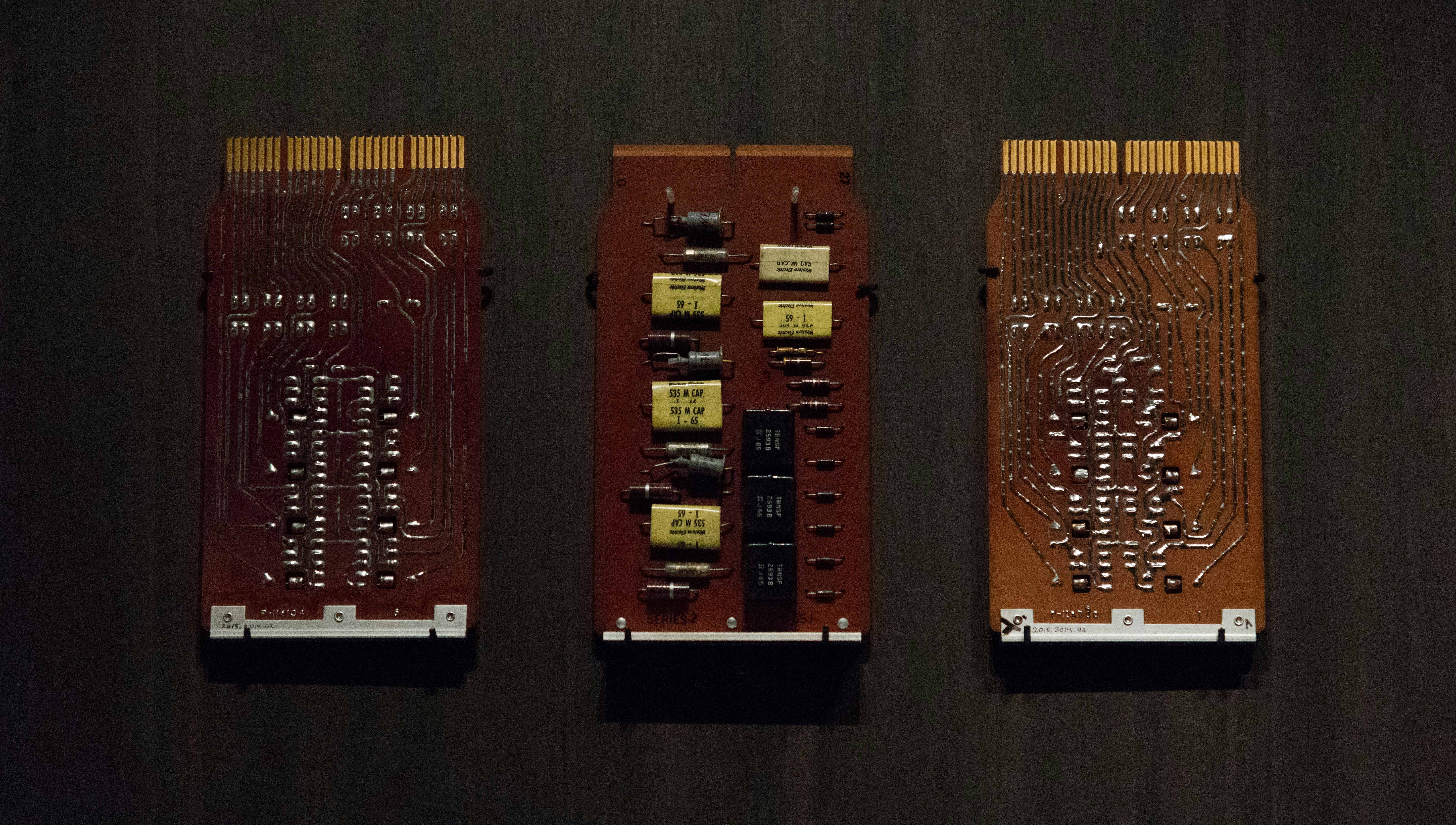 Vintage computer circuit board in dim industrial lighting, dark metallic tones and shadows