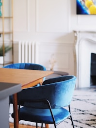 a living room with a fireplace and blue chairs