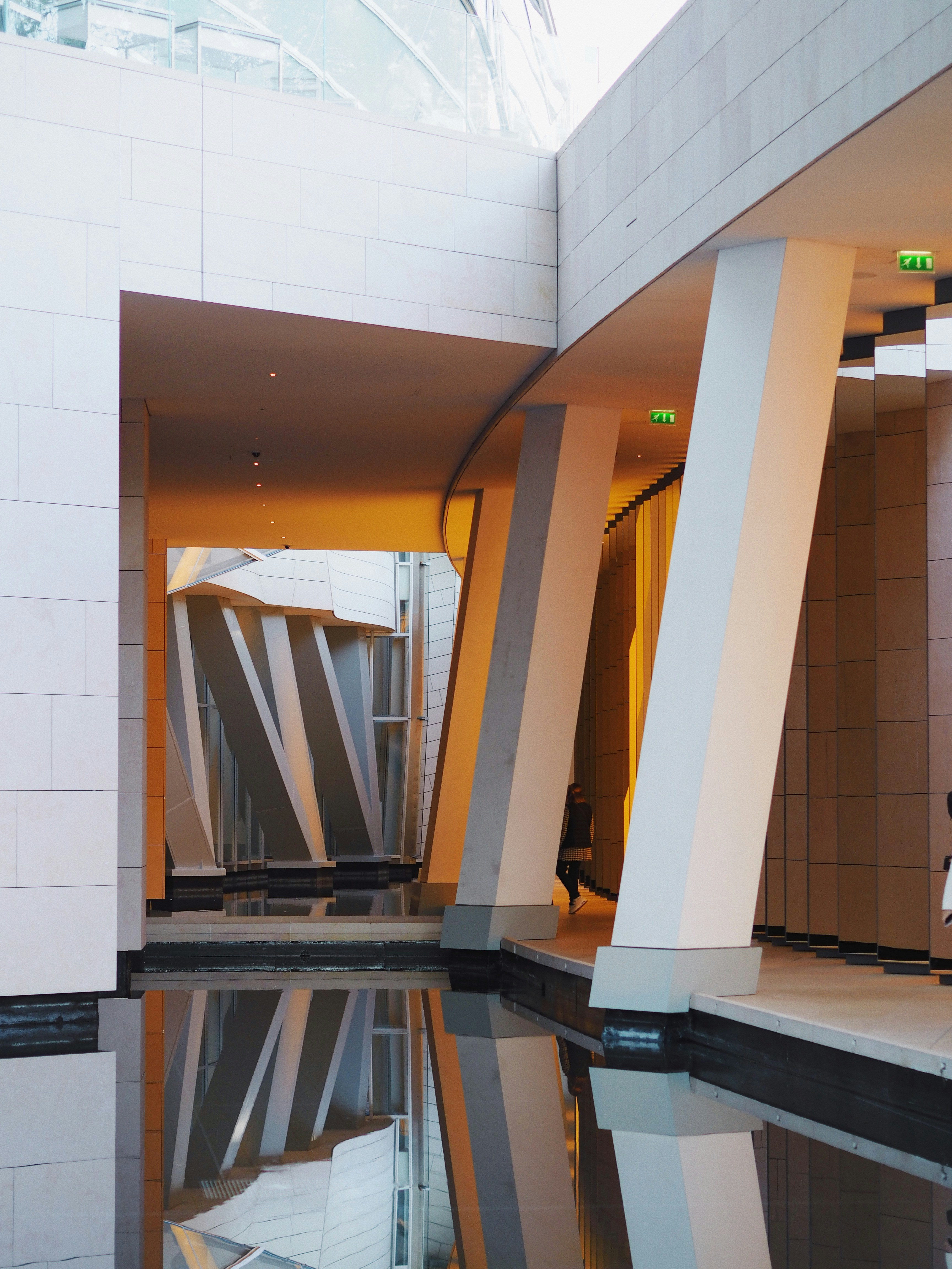 a person sitting on a bench near a pool of water