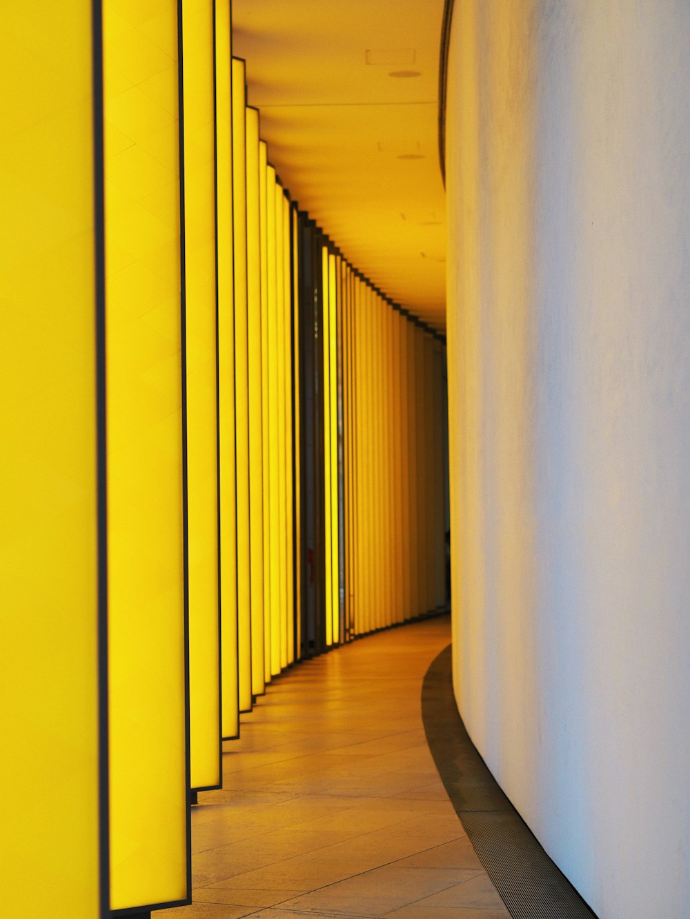 Un largo pasillo con paredes amarillas y un reloj en la pared
