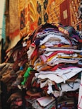 a pile of cloths on a stand in front of a building