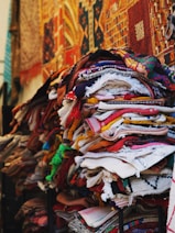 a pile of cloths on a stand in front of a building