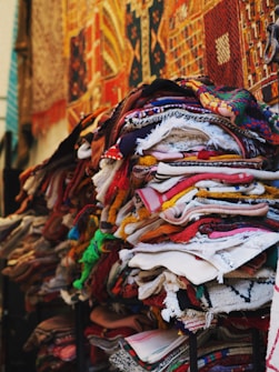 a pile of cloths on a stand in front of a building