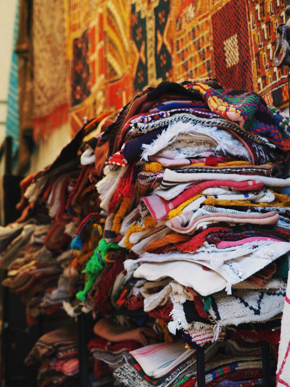 a pile of cloths on a stand in front of a building