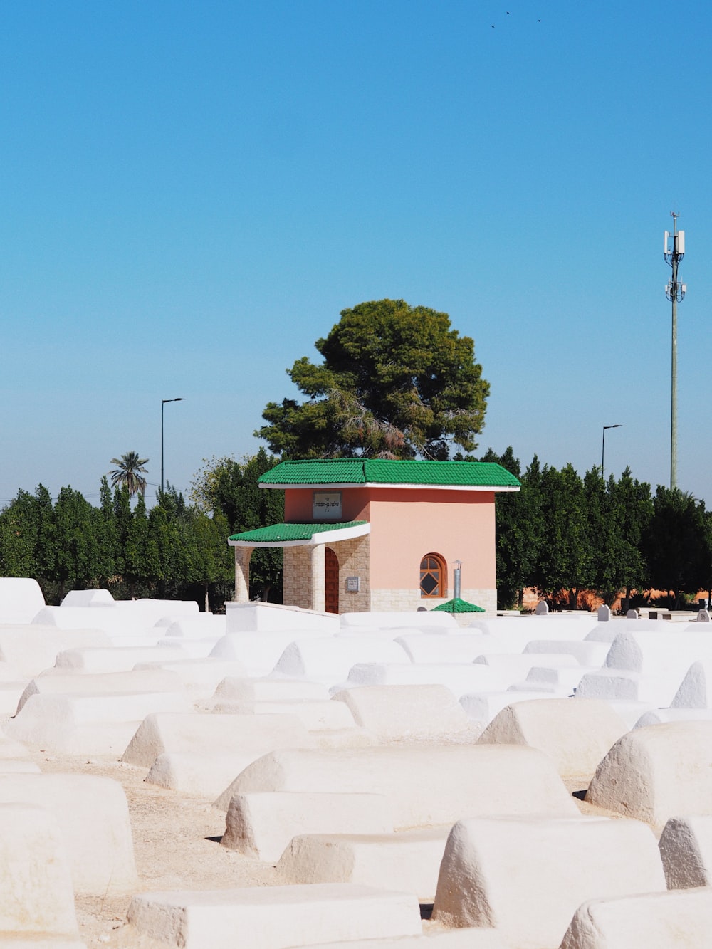 a building with a green roof surrounded by white sand
