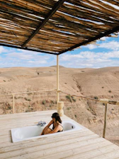 Inviting outdoor bathtub on a wooden terrace surrounded by jungle.