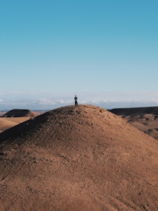 a person standing on top of a large mound of dirt