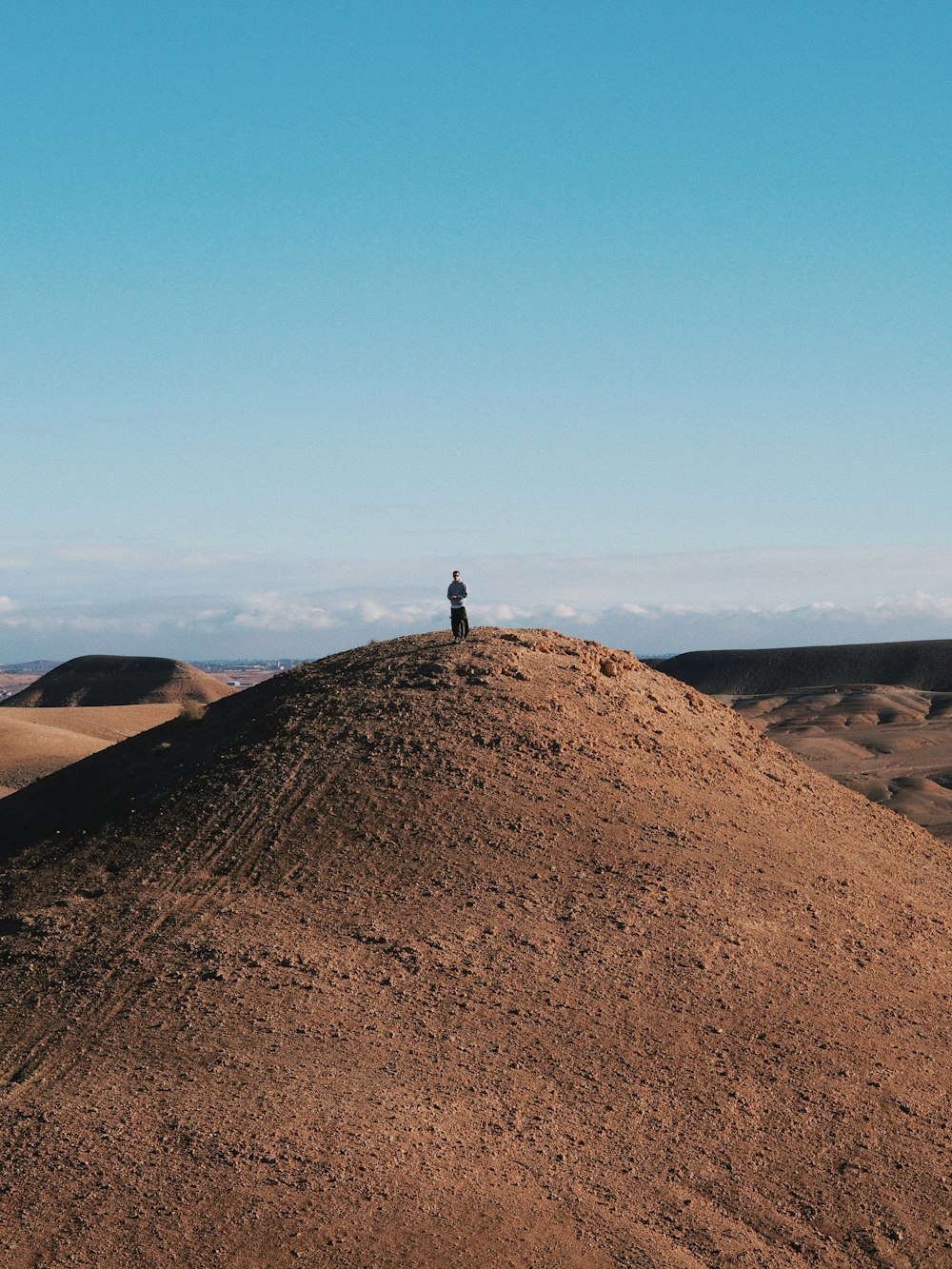 a person standing on top of a large mound of dirt