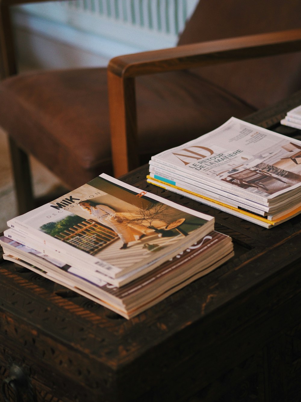 a stack of magazines sitting on top of a wooden table