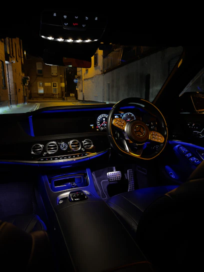 A sleek, modern car dashboard illuminated with soft blue lights at dusk.