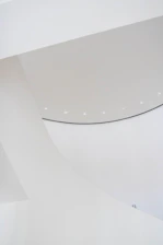 Minimalist architectural model displayed on a clean white surface with soft natural lighting.