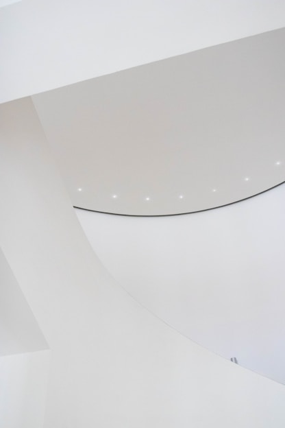 A sleek, modern architectural model bathed in soft teal lighting, highlighting clean lines and minimalist form.