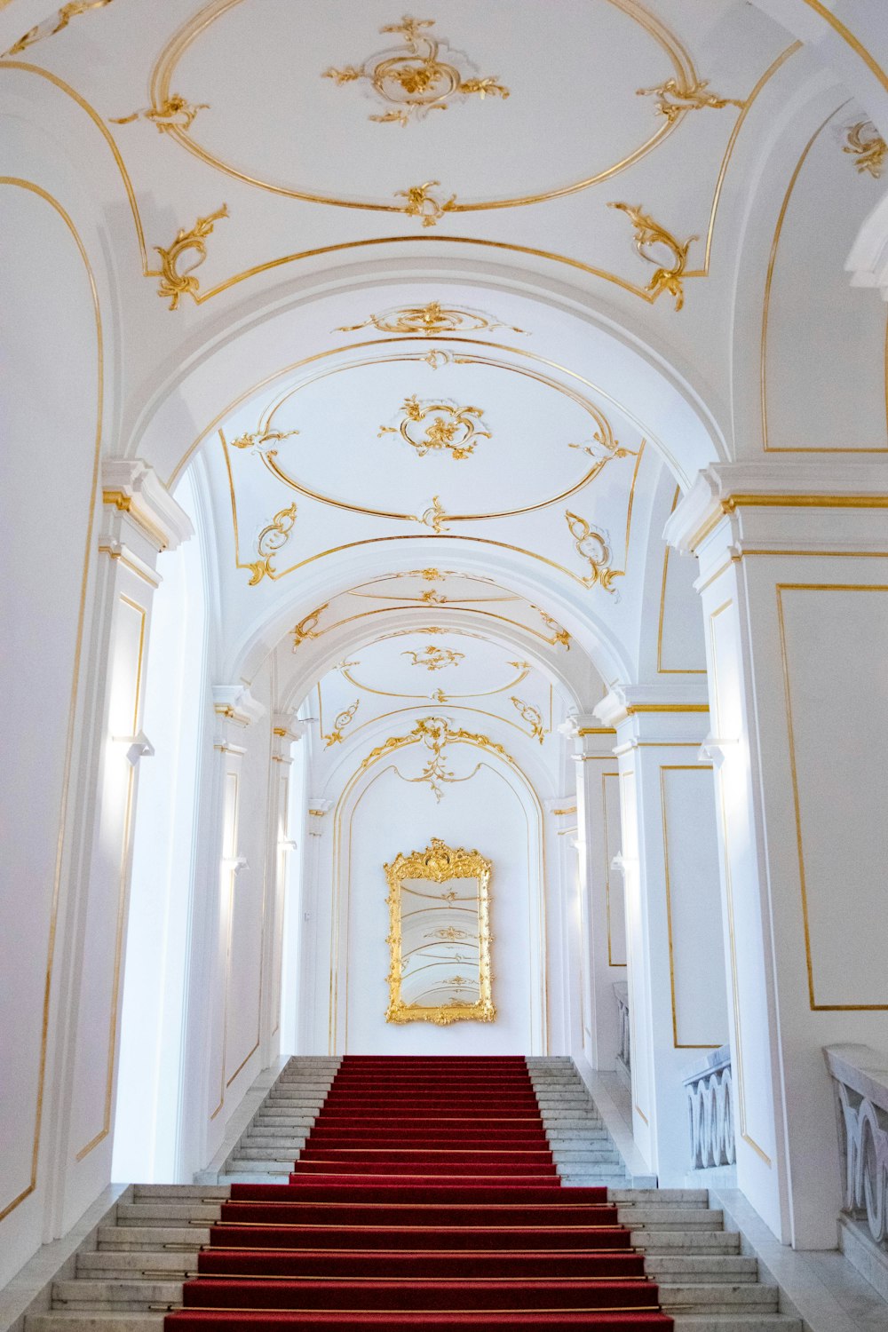 a red carpeted staircase leading up to a white building