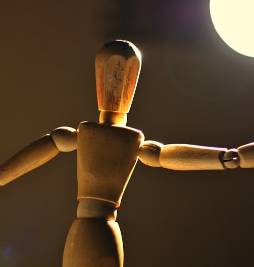 a wooden toy standing in front of a light