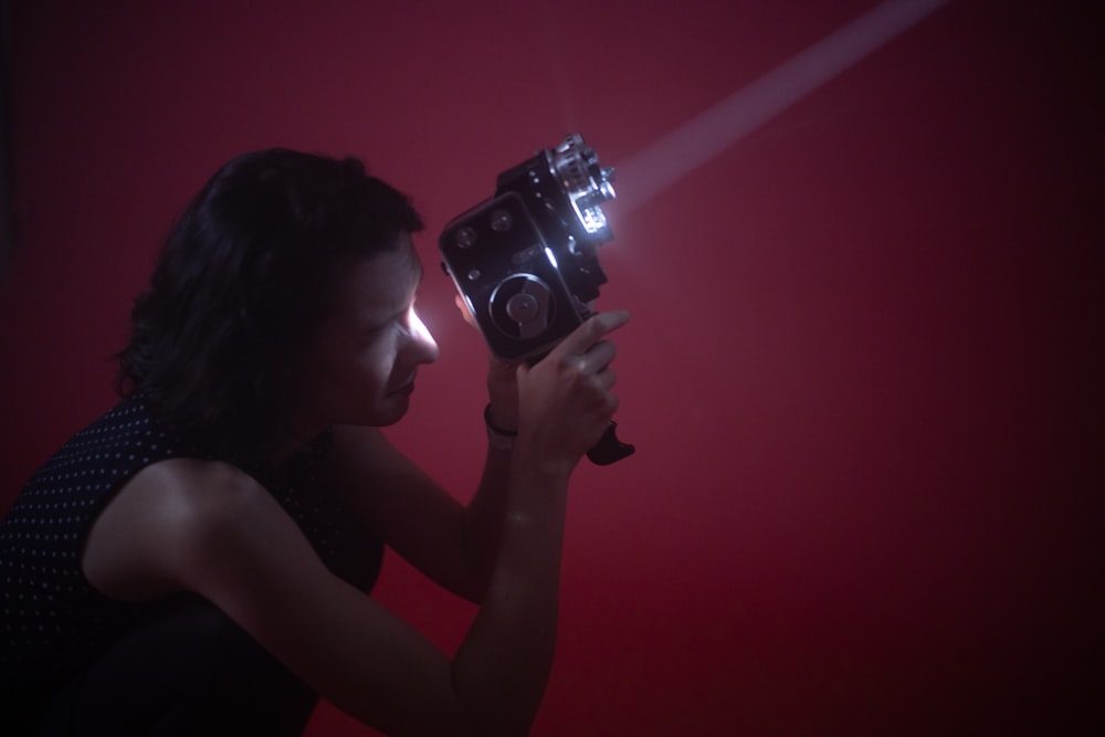 a woman holding a camera in a dark room