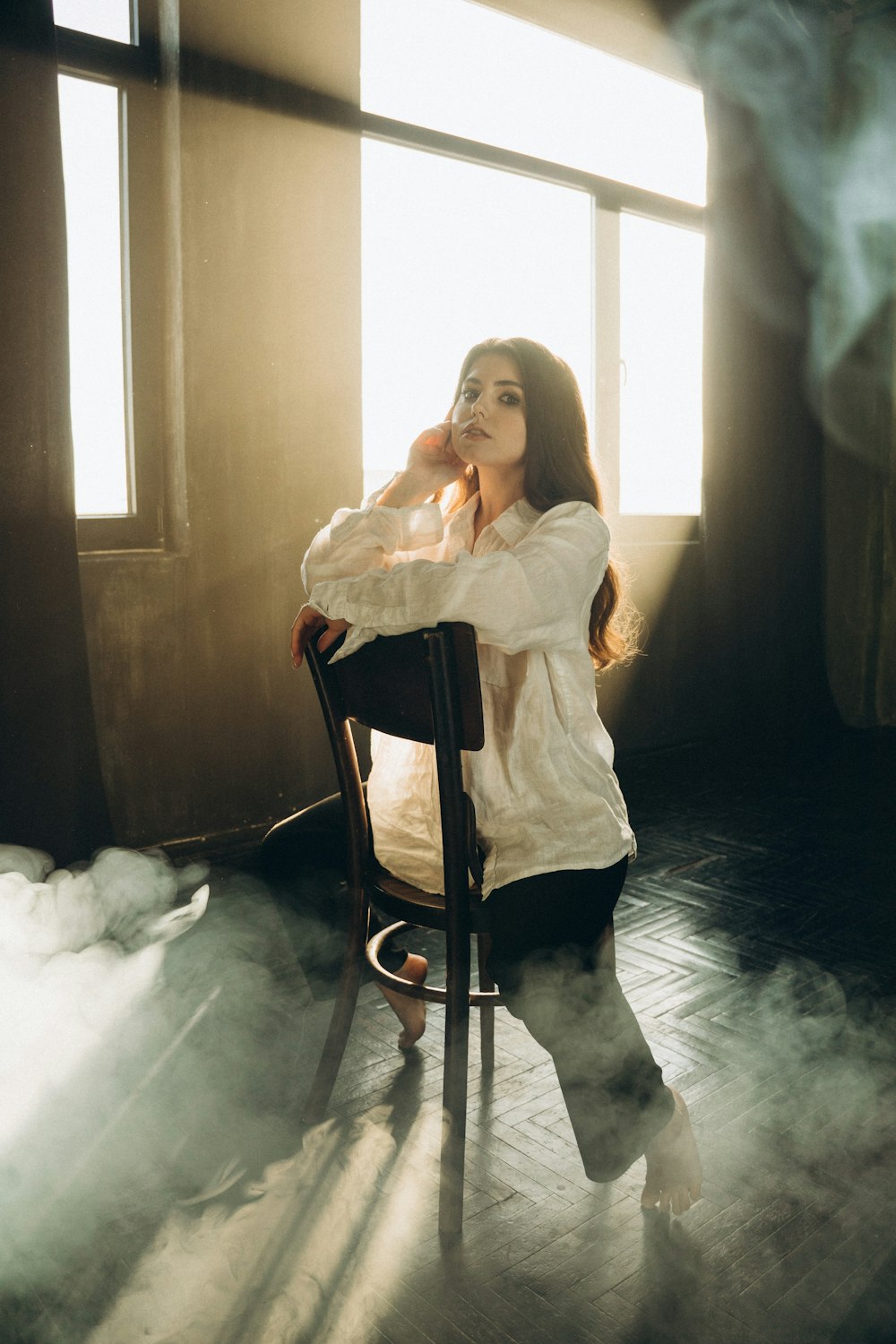 a woman sitting on a chair in front of a window