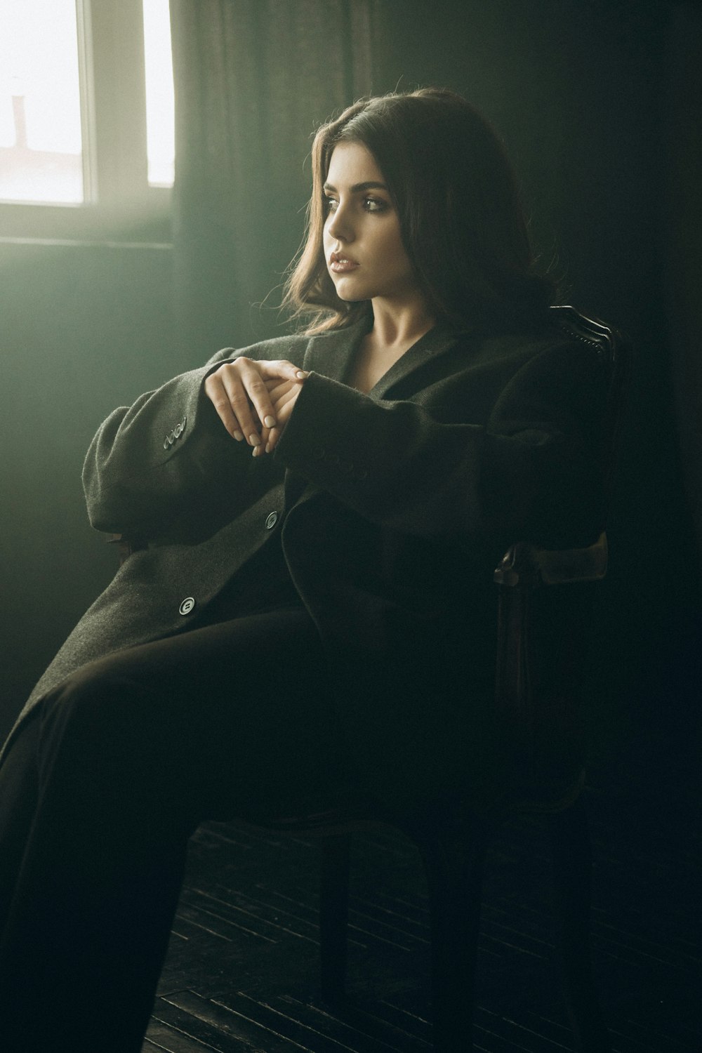 a woman sitting in a chair in a dark room
