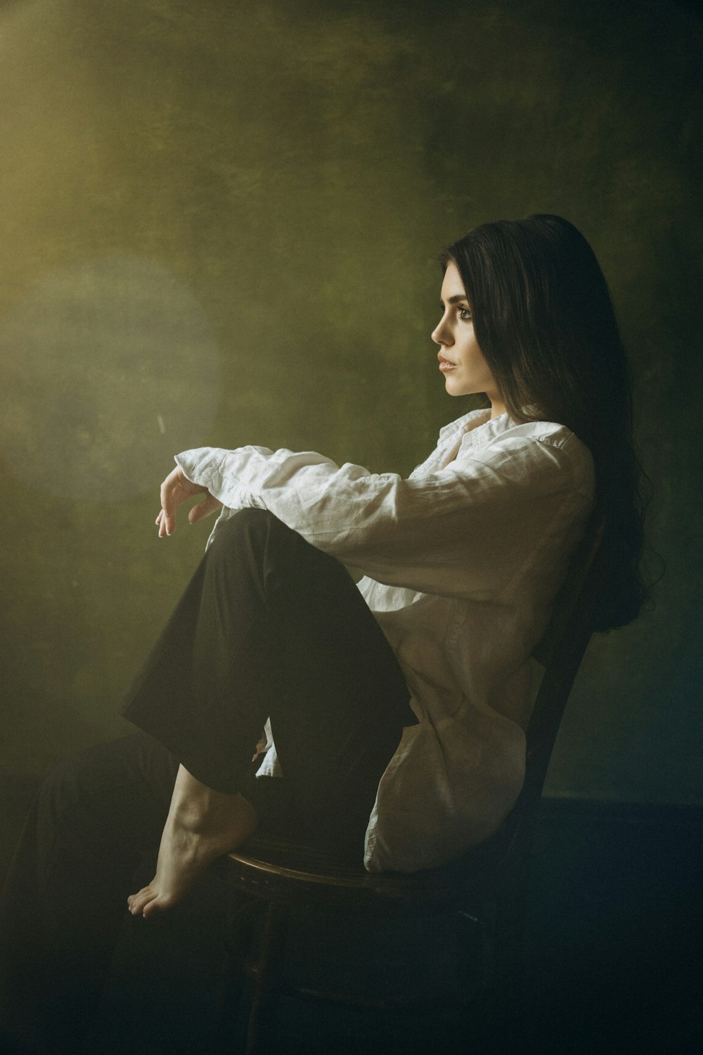 a woman sitting in a chair with her legs crossed