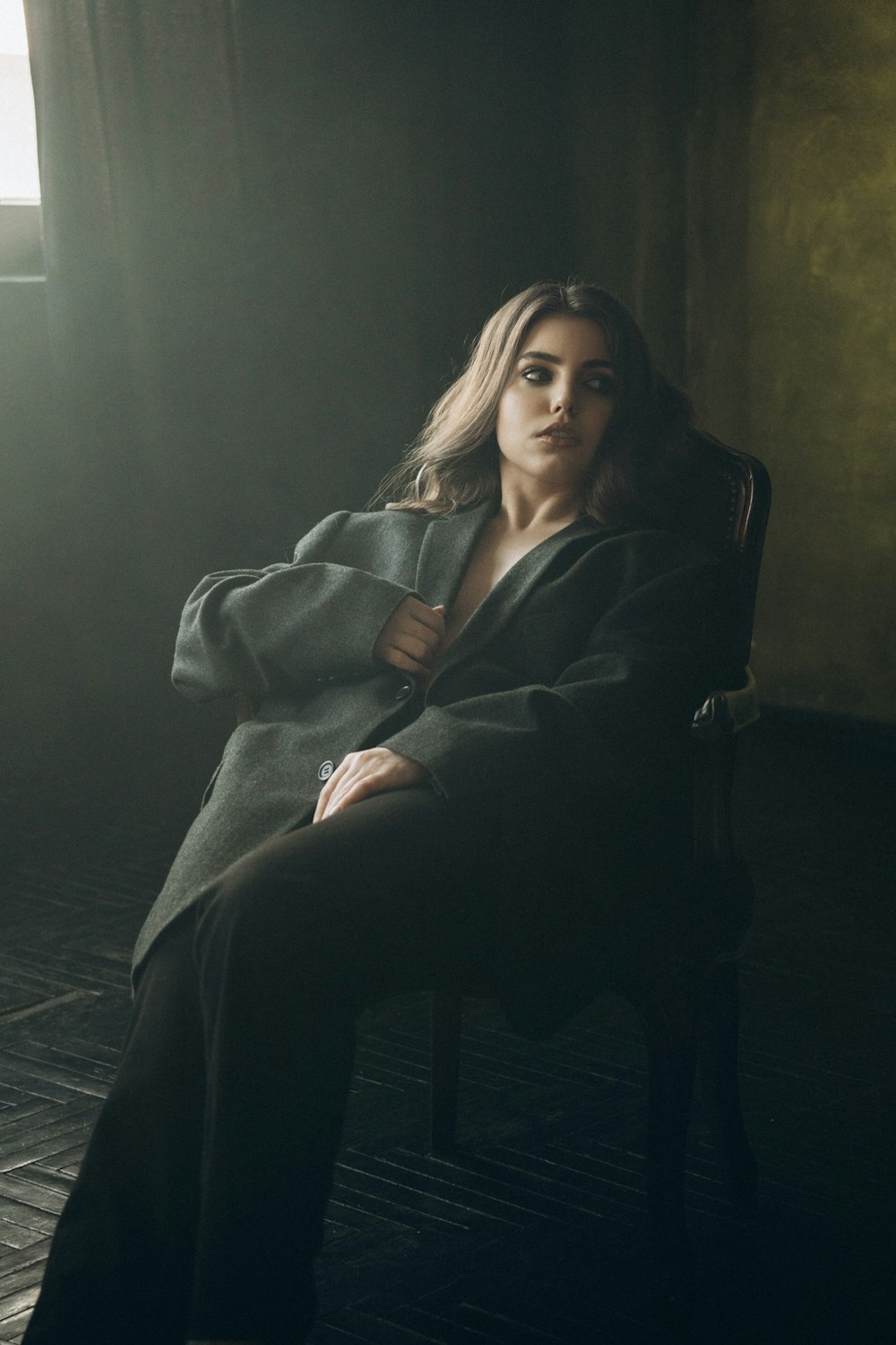 a woman sitting in a chair in a dark room