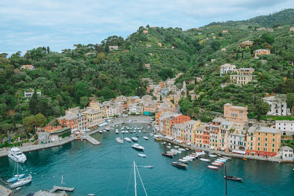 A harbor filled with lots of boats next to a lush green hillside — Portofino, Italy
