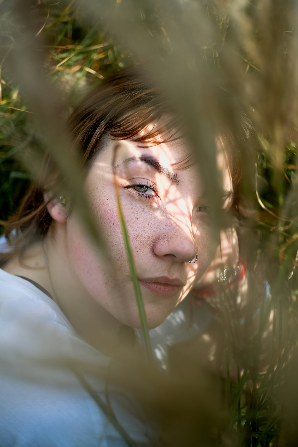 Una donna con i capelli lentigginosi e gli occhi lentigginosi che guardano la macchina fotografica