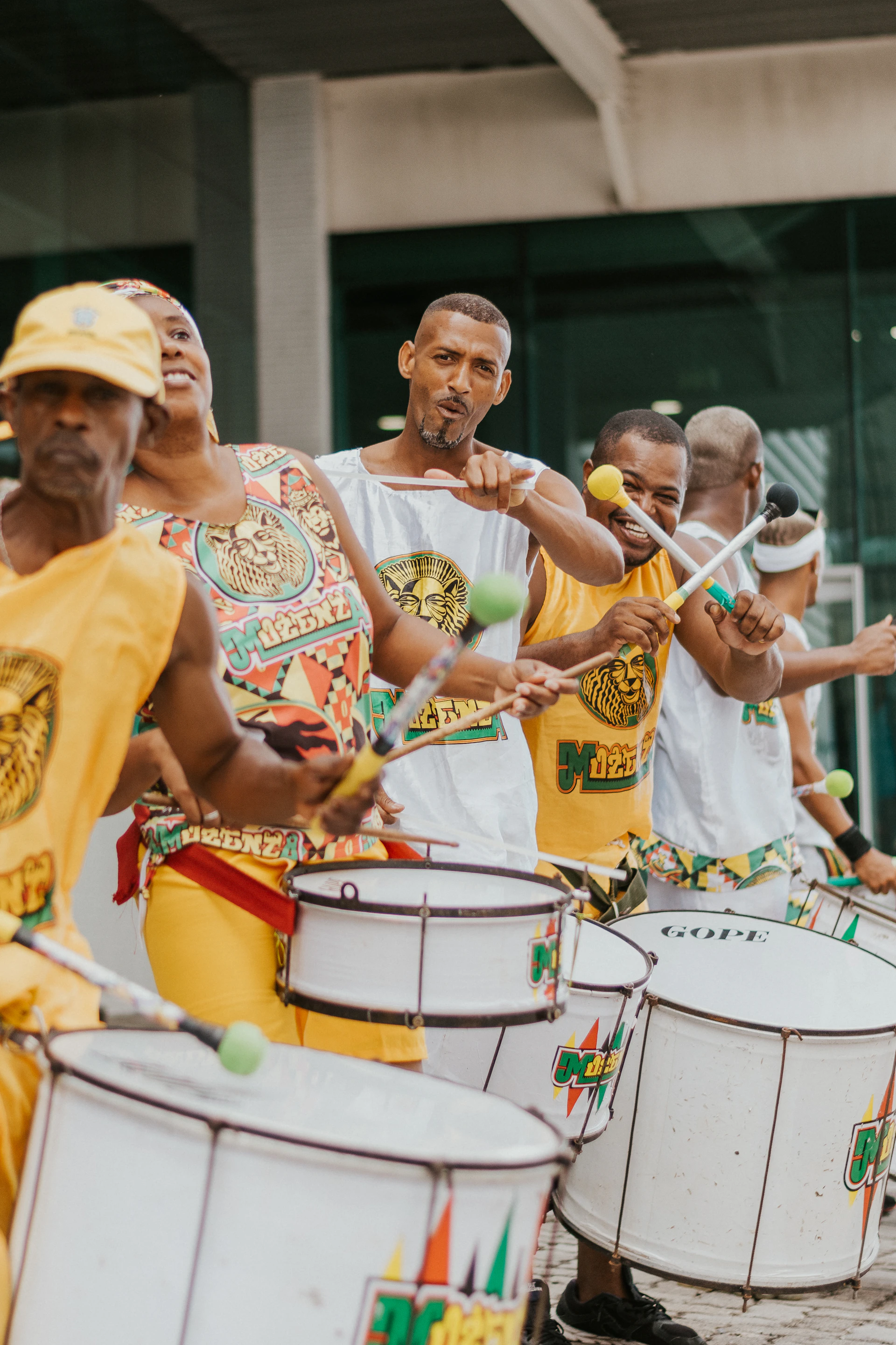 a group of men playing drums in front of a building